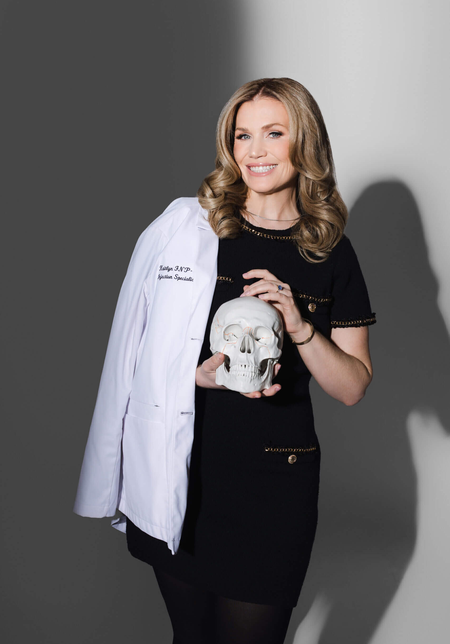 Smiling woman holding skull with lab coat